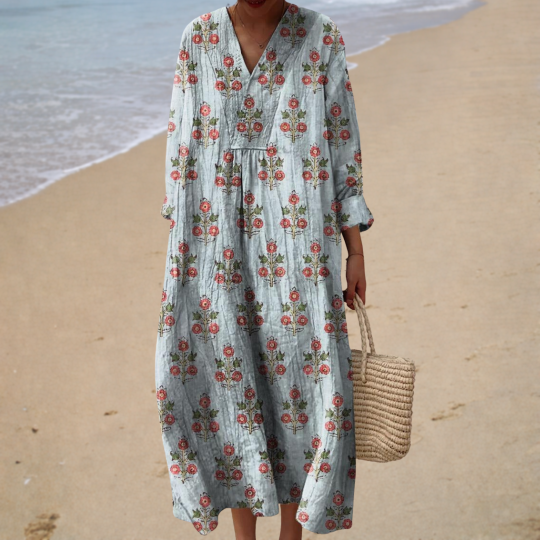 A woman wearing a fluttering printed summer dress, relaxed and breezy on a bright sunny day.