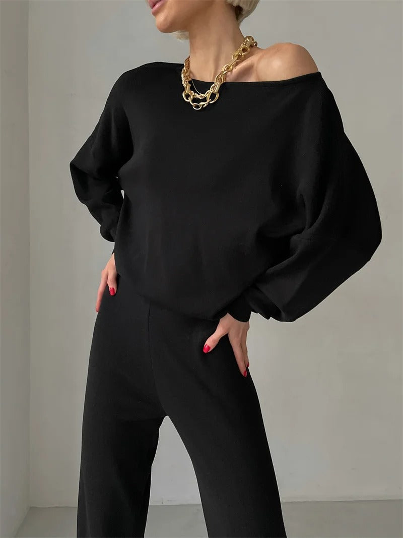 A woman wearing an off-shoulder draped top with wide-leg pants