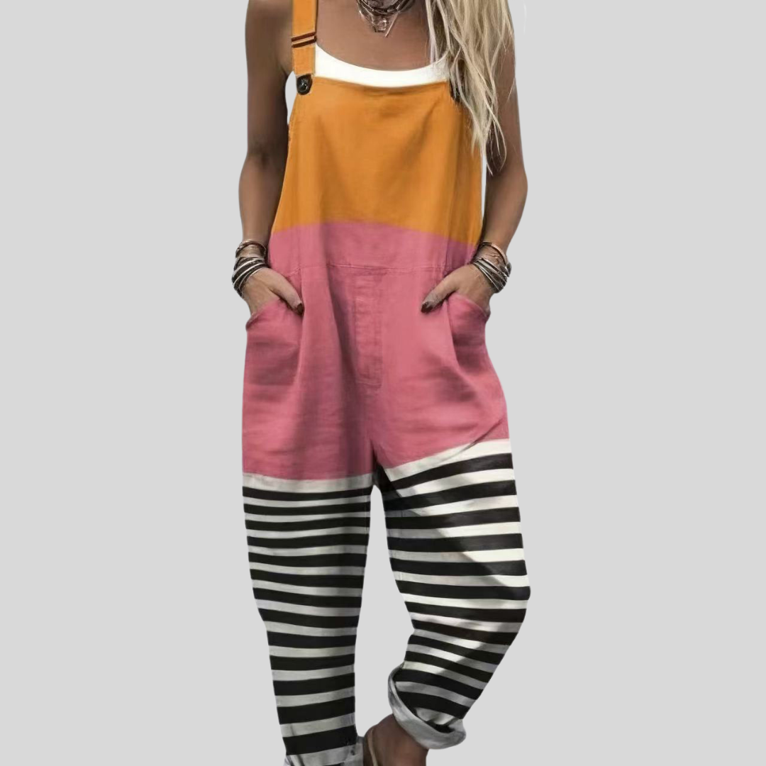 A woman wearing bold colour-block overalls in orange and pink with striped legs and adjustable straps.