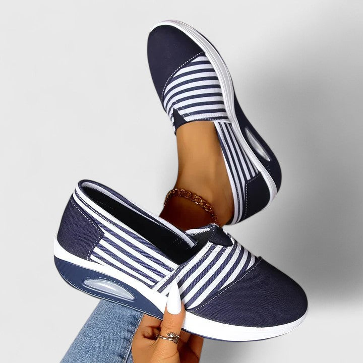A woman wearing blue striped orthopaedic sneakers on a walk