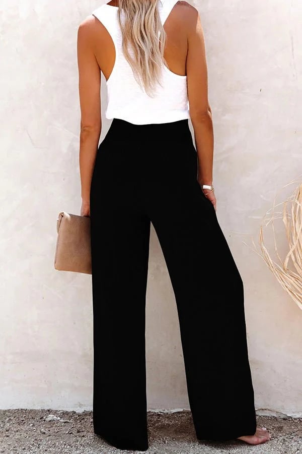 A woman in high-waisted loose wide-leg pants with subtle button detailing, styled for an elegant everyday look.