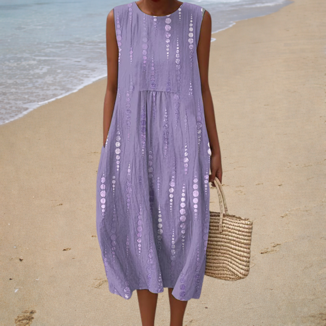 A woman wearing a sleeveless printed summer dress, relaxed and cool on a bright summer day.