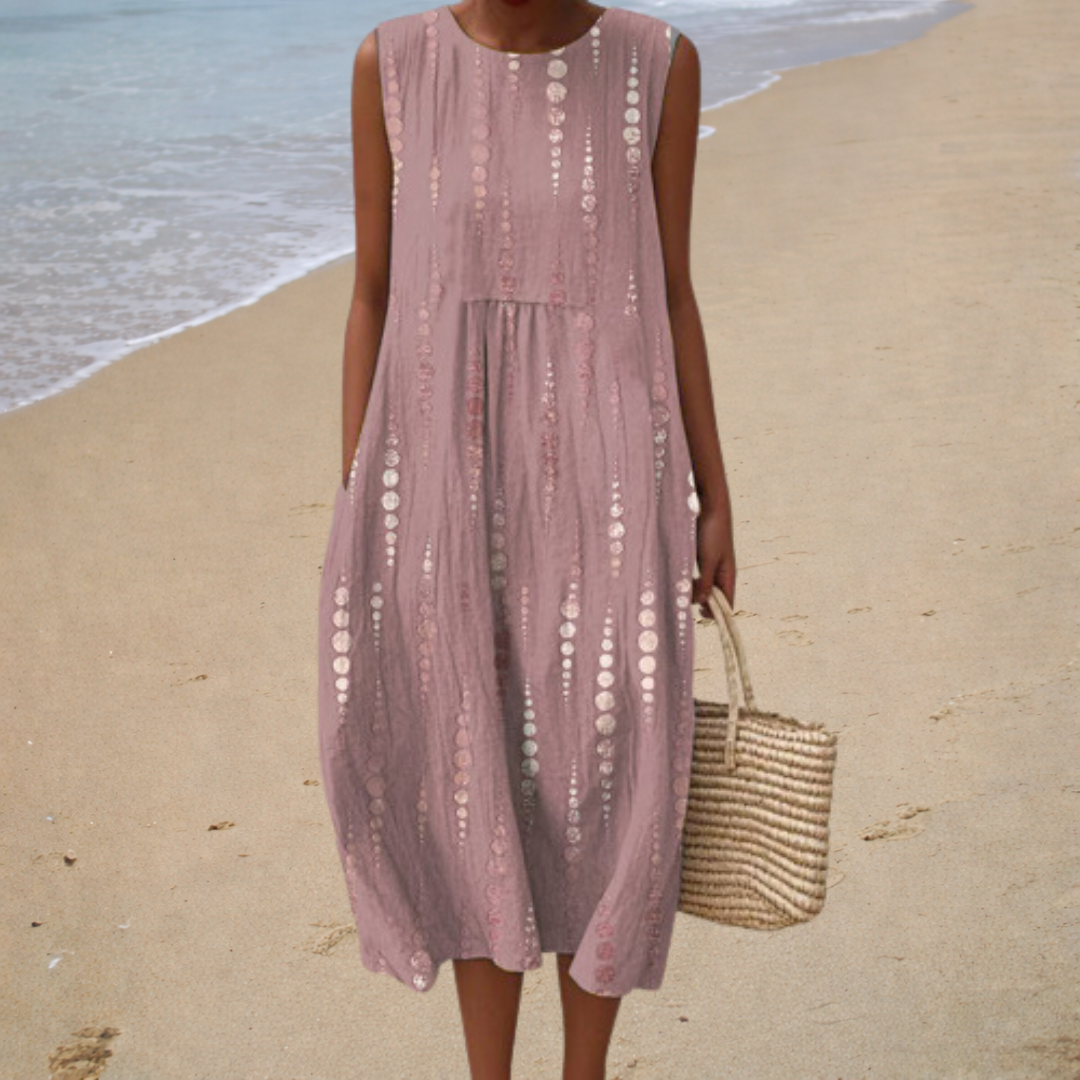 A woman wearing a sleeveless printed summer dress with bare shoulders on a hot, sunny day.
