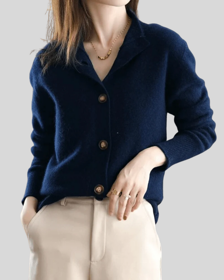 A woman wearing a beige retro button cardigan layered over a dress, warm and elegant.