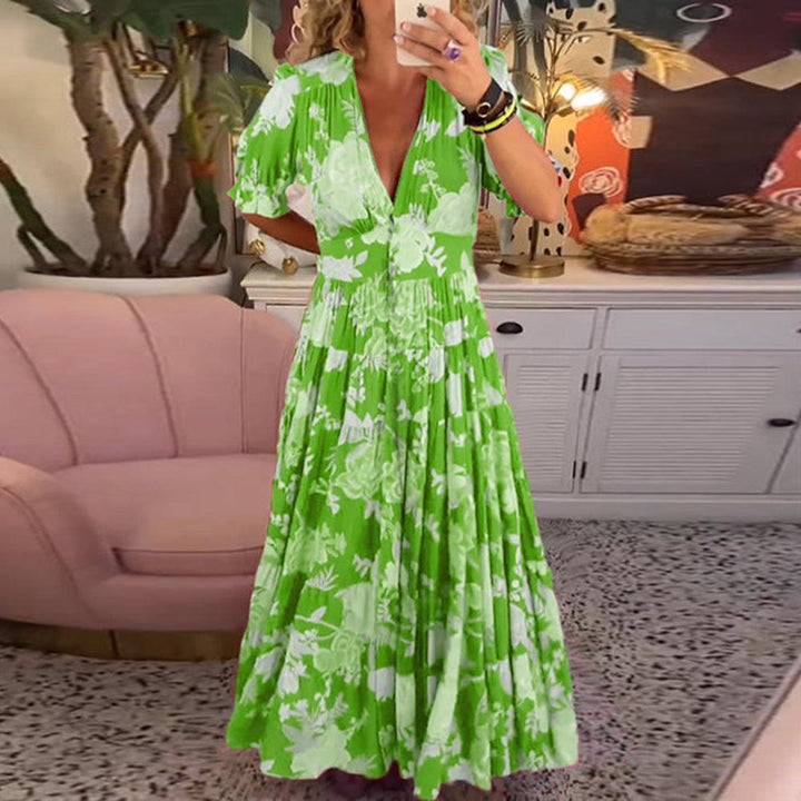 A woman wearing the Dawn bold floral maxi dress with a flowing full-length skirt at a garden gathering.