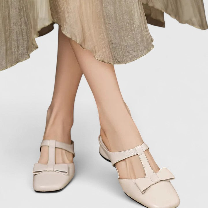 Soft green bow-detail mules with a slim T-strap, open back and a low heel.