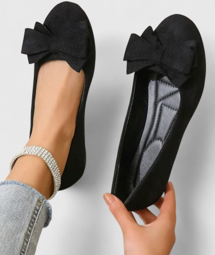 A pair of olive-green ballet flats with a soft bow at the rounded toe.
