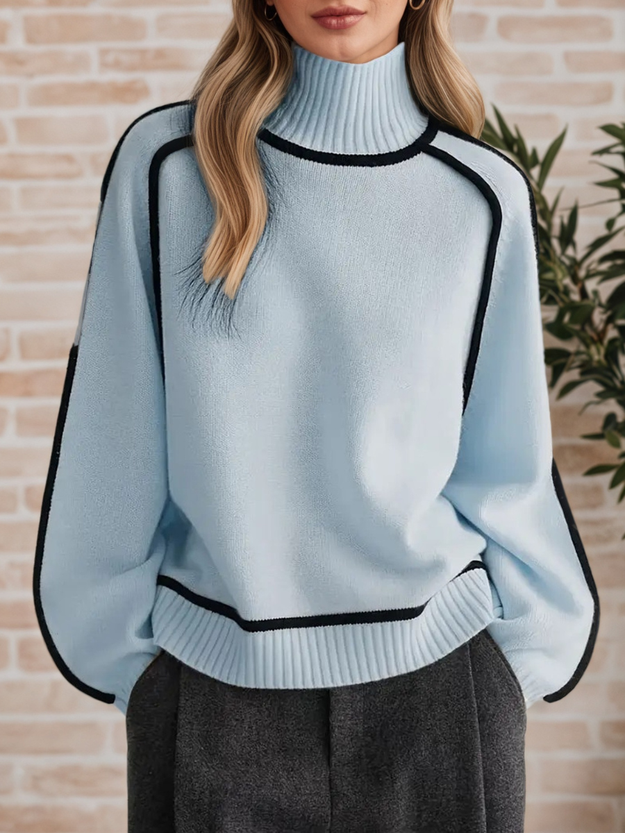 A woman wearing a funnel neck sweater with contrast piping, styled with pants for a smart-casual look.