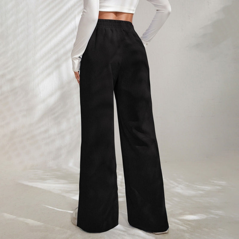Woman wearing wide-leg ribbed joggers with a fitted top, relaxed at home.