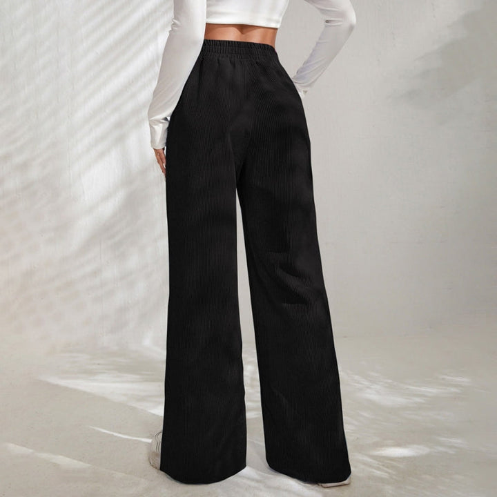 Woman wearing wide-leg ribbed joggers with a fitted top, relaxed at home.