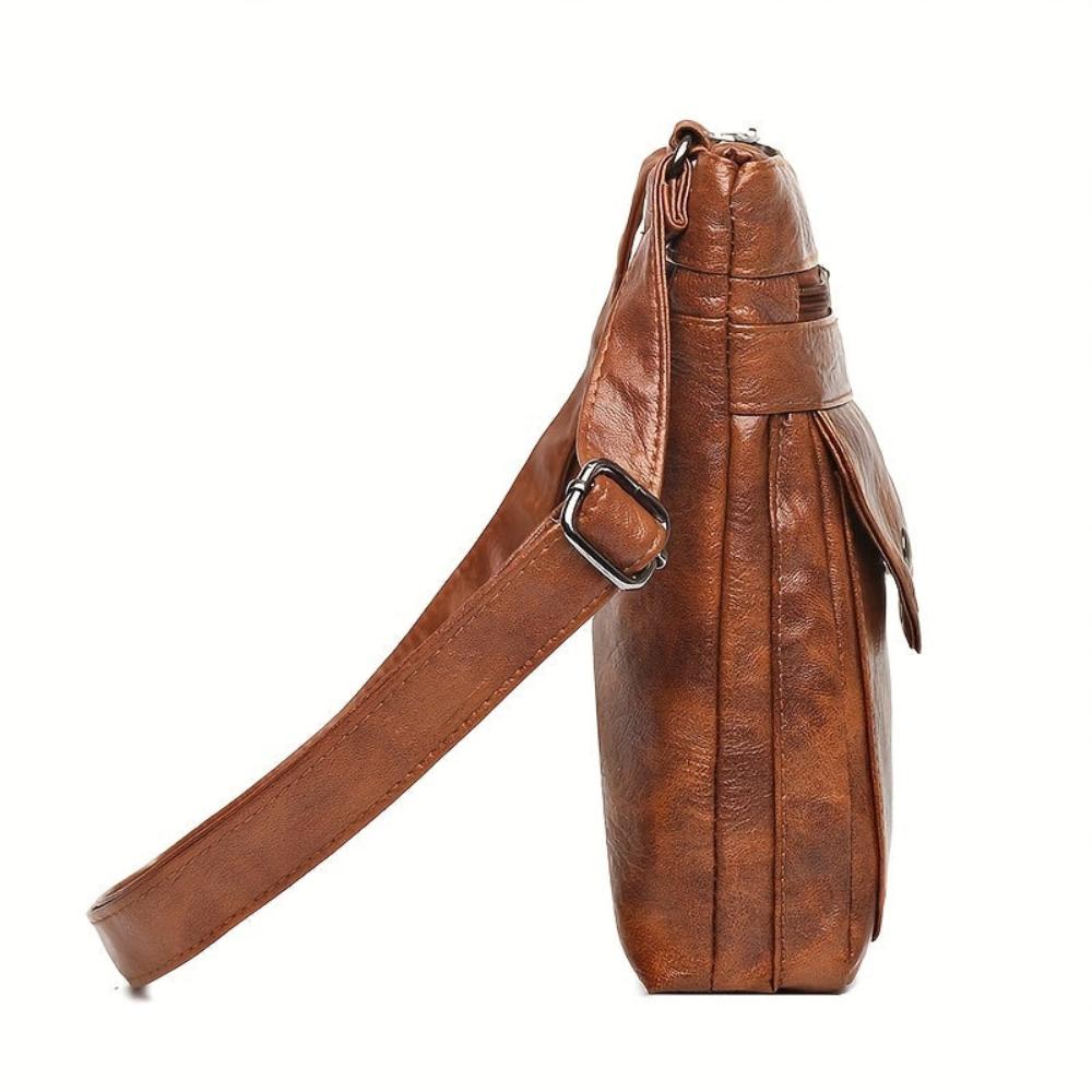 A woman wearing a compact vintage crossbody bag across her body while walking through town.