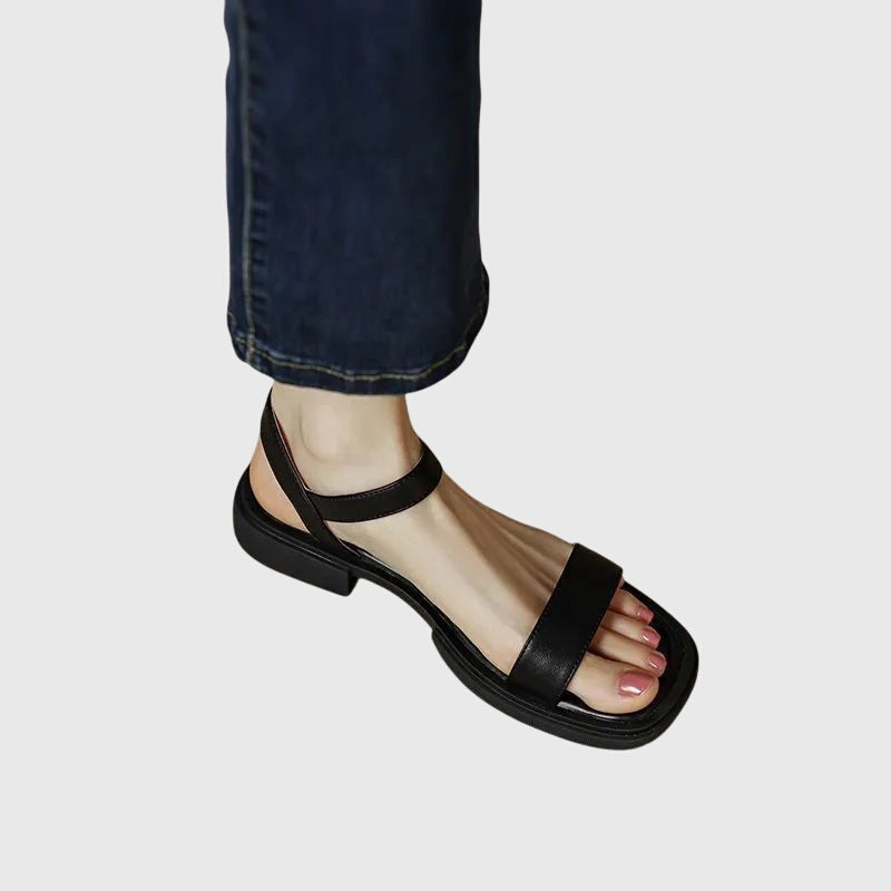 A woman in white square-toe ankle-strap sandals dressed for a summer brunch.