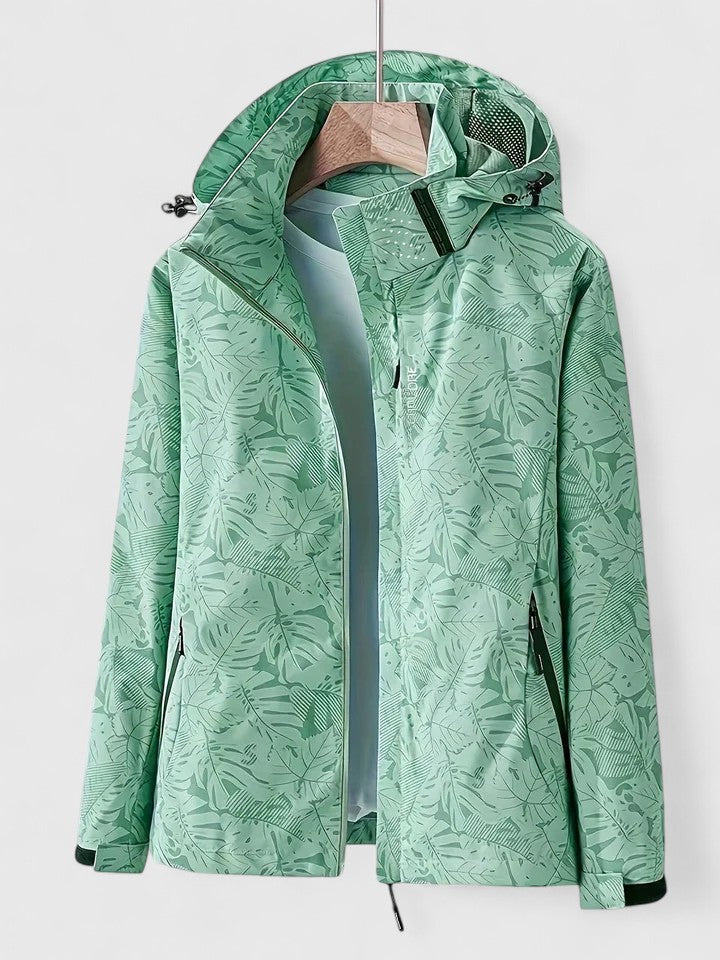 A woman wearing a botanical leaf-print jacket with a hood outdoors