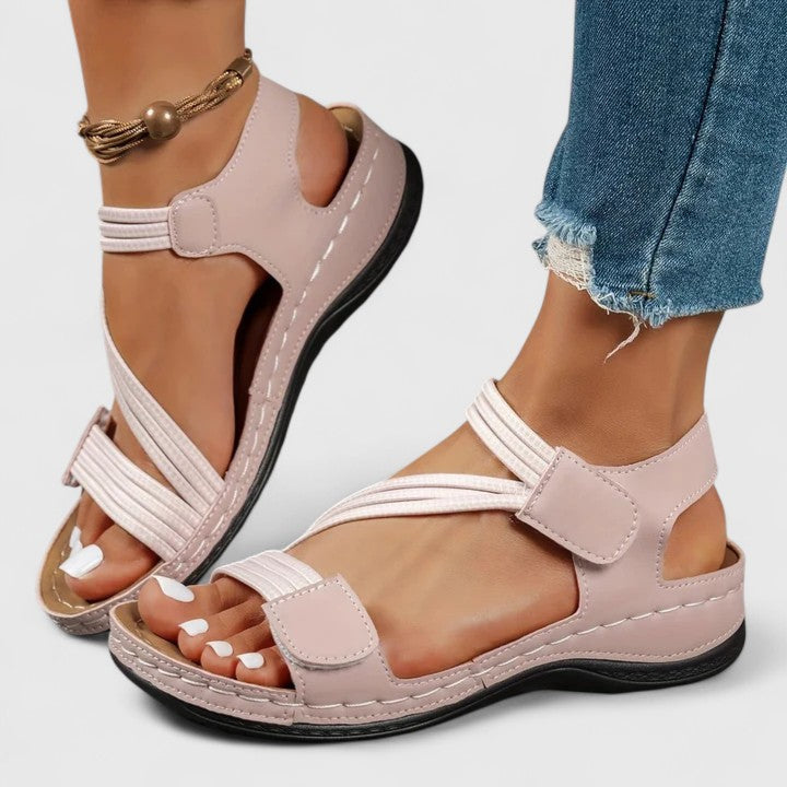 A woman wearing soft adjustable comfort sandals with a summer outfit, looking relaxed and content.