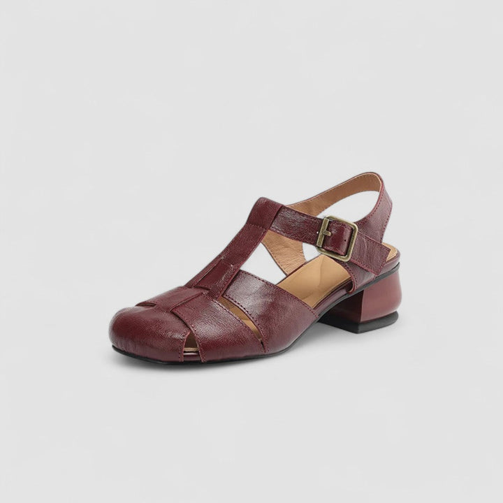 A woman in burgundy closed-toe woven sandals with a low block heel, comfortable browsing a market.
