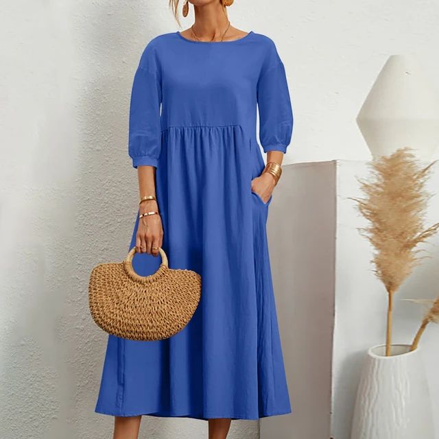 A woman wearing the Barbara fitted waist midi dress with three-quarter sleeves and a flowing skirt.
