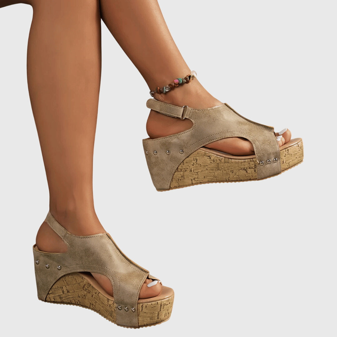 A woman in studded wedge sandals with an open front at a summer event.