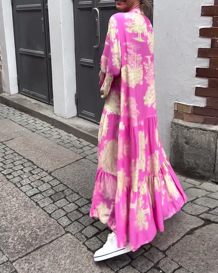 Woman wearing the Sylvie flowing maxi dress with a delicate print and V-neckline, the skirt moving softly as she walks.