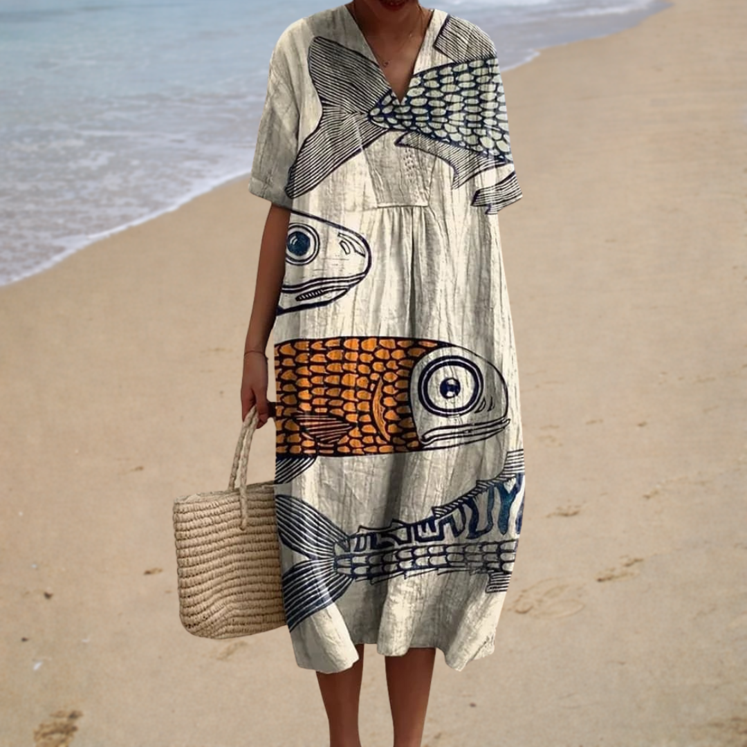 A woman wearing a flowing printed dress that moves softly around her at a warm summer gathering.
