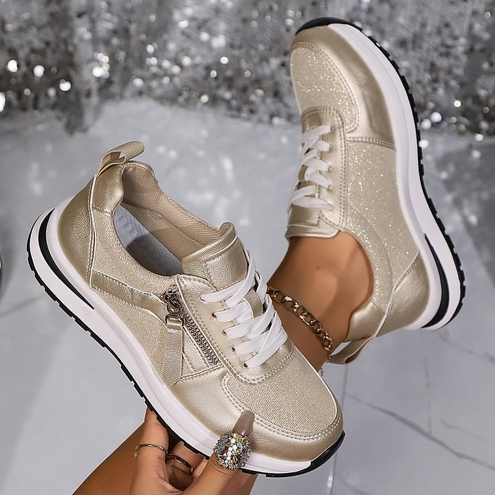 A woman in silver orthopaedic sneakers with a handy side zip.