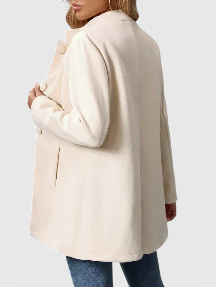 A woman wearing a tailored jacket with a neat stand collar and a button front