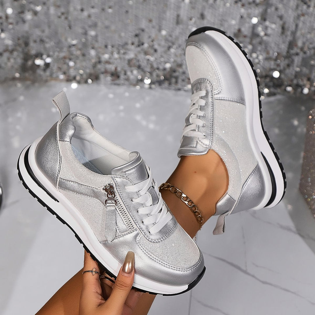 A woman in silver orthopaedic sneakers with a handy side zip.