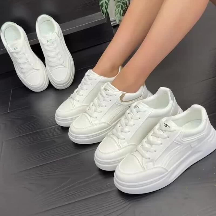 A woman in crisp white light comfort sneakers paired with jeans.