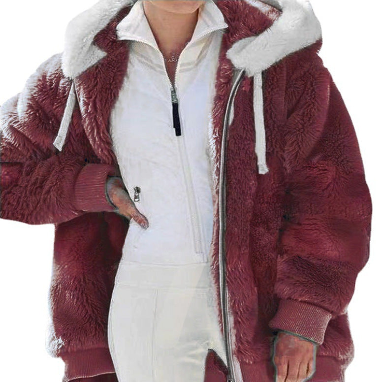 A woman wearing a plush oversized hooded zip jacket in blue and cream colour-block panels.