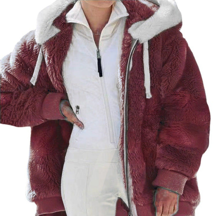 A woman wearing a plush oversized hooded zip jacket in blue and cream colour-block panels.
