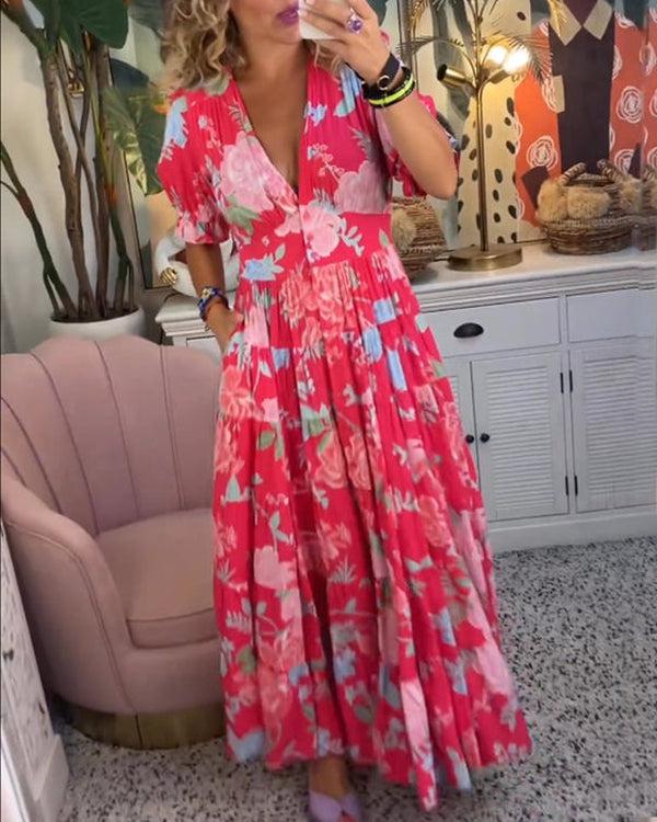 A woman wearing the Dawn bold floral maxi dress with a flowing full-length skirt at a garden gathering.