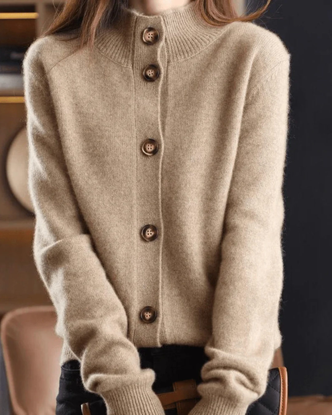 A woman wearing a beige retro button cardigan layered over a dress, warm and elegant.
