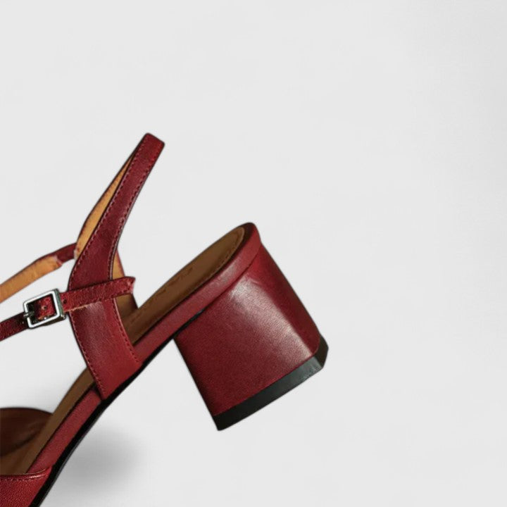 Burgundy closed square-toe flats with criss-cross instep straps and a buckled slingback.