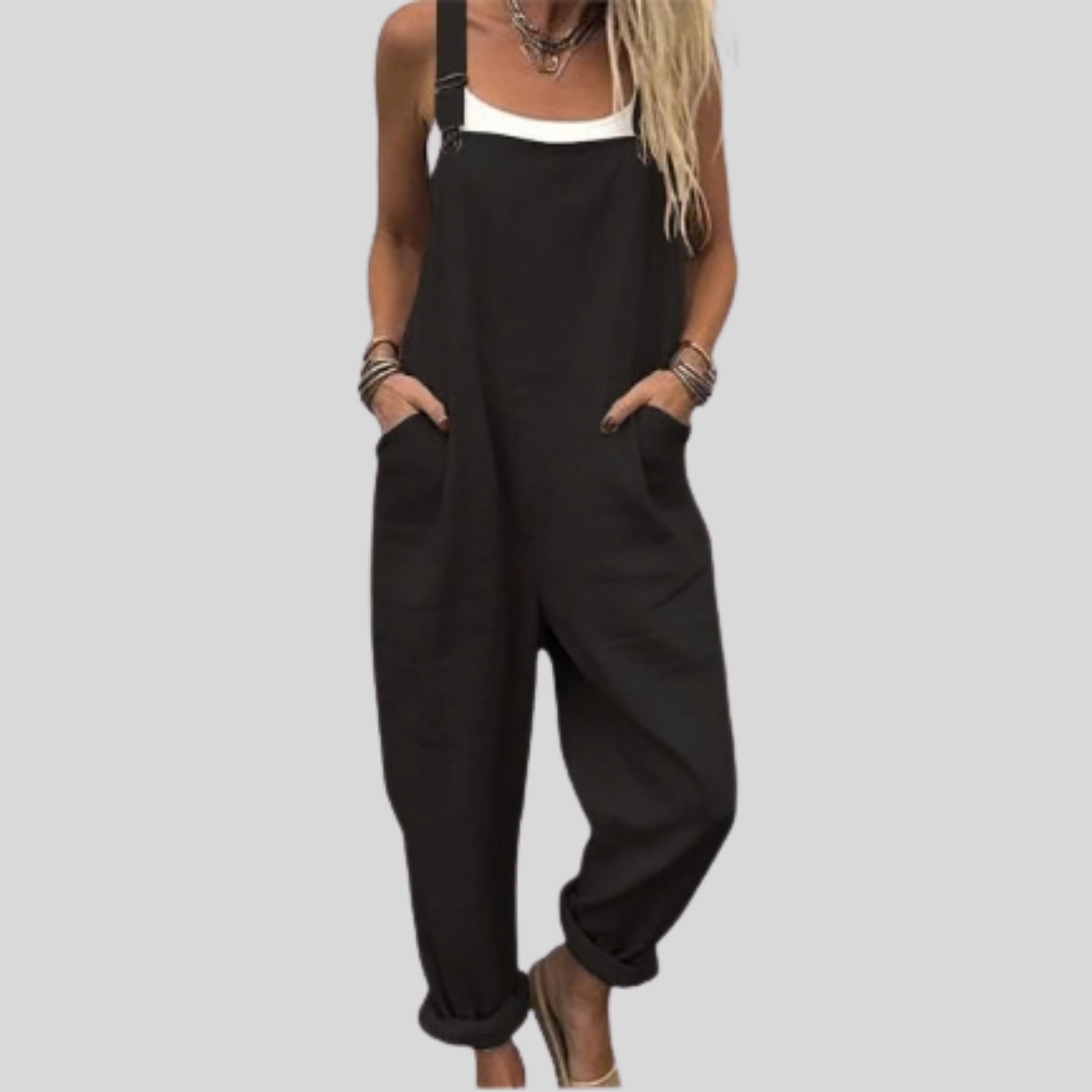 A woman wearing classic plain black overalls with a white blouse.