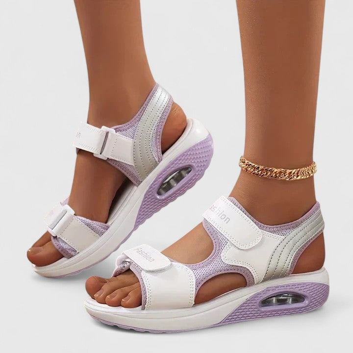 A woman in white sandals with a lilac trim walking comfortably, feet supported and light.