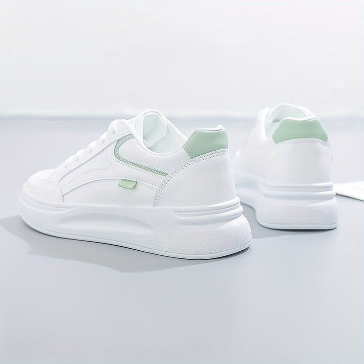 A woman in crisp white light comfort sneakers paired with jeans.