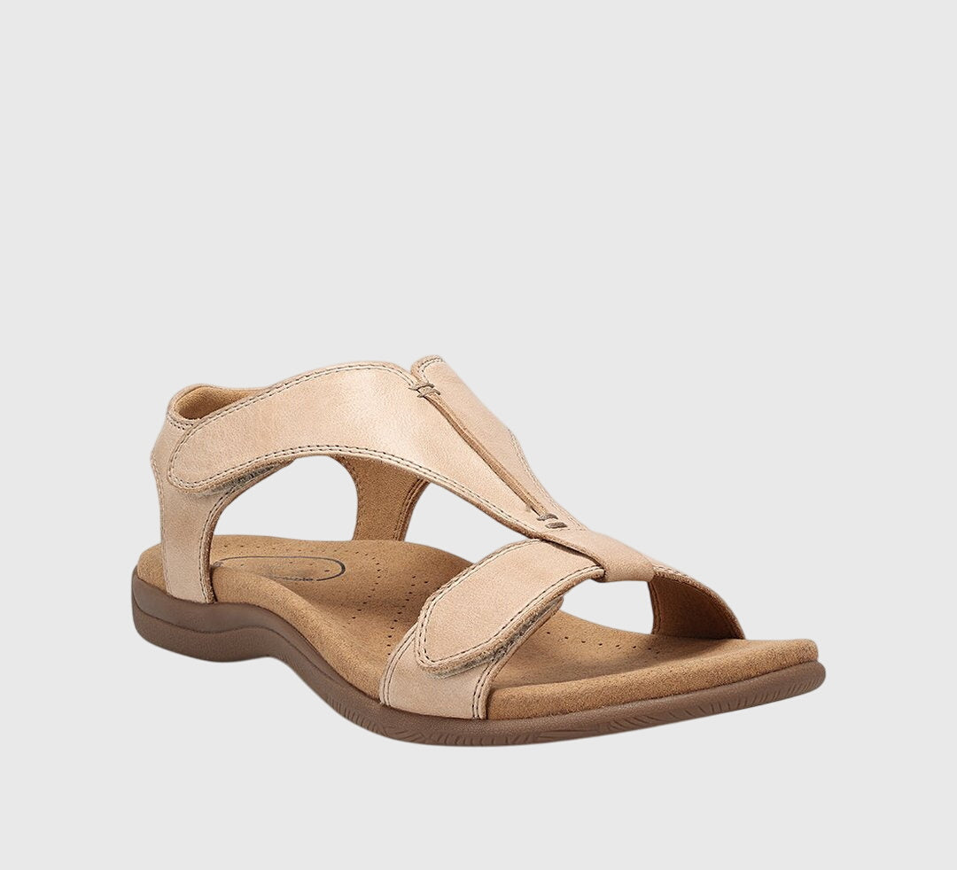 A woman wearing T-strap comfort sandals with a summer dress, looking relaxed and elegant.