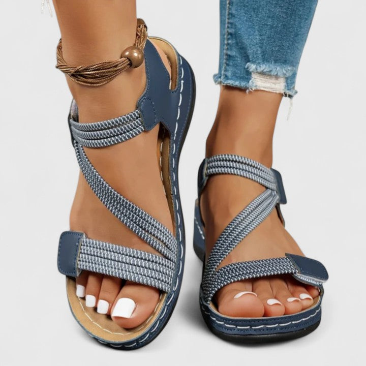 A woman wearing soft adjustable comfort sandals with a summer outfit, looking relaxed and content.
