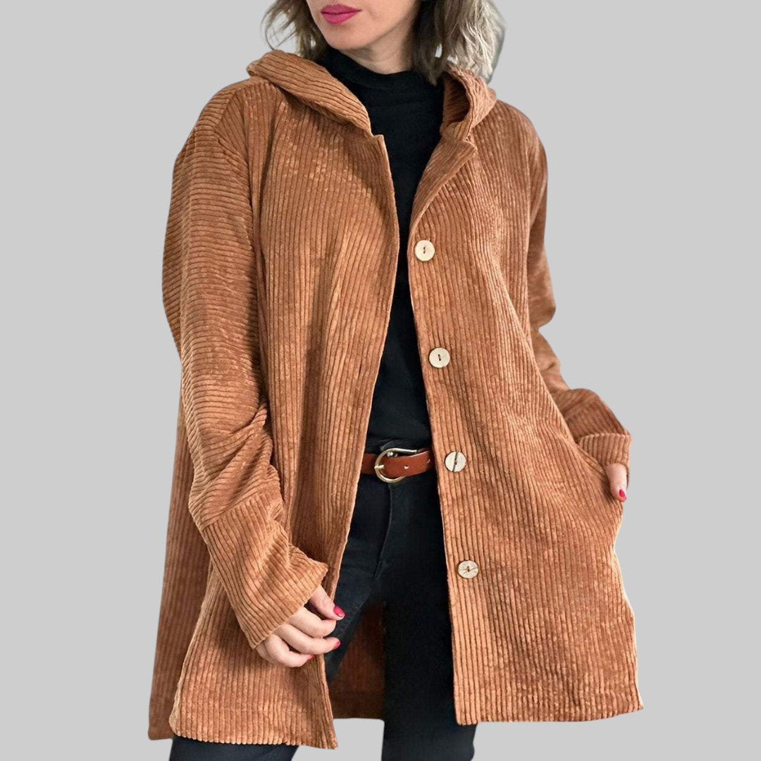 A woman wearing a hooded textured jacket outdoors in fall