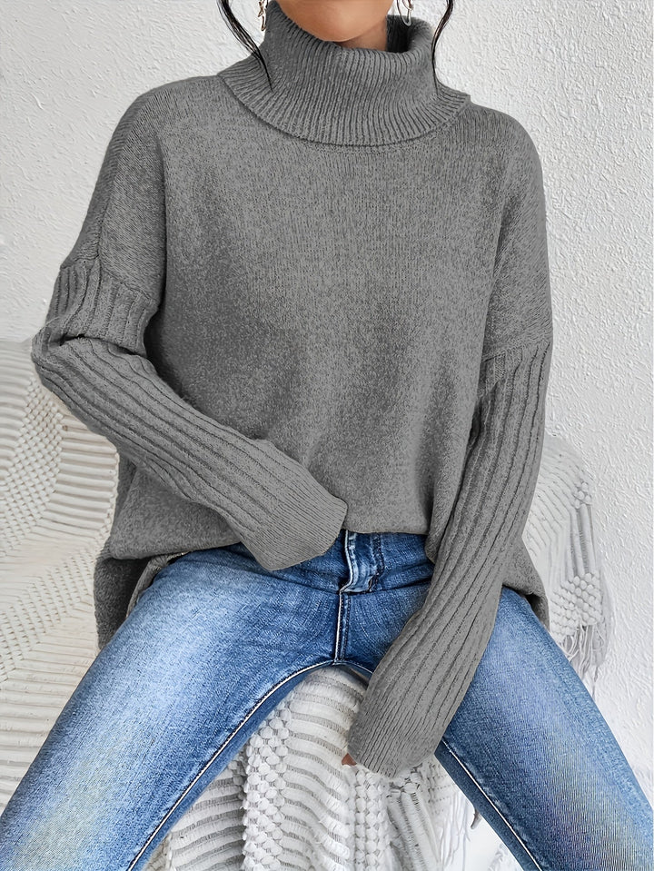 A woman wearing a stand-collar sweater with a chic asymmetric drape, warm and polished.