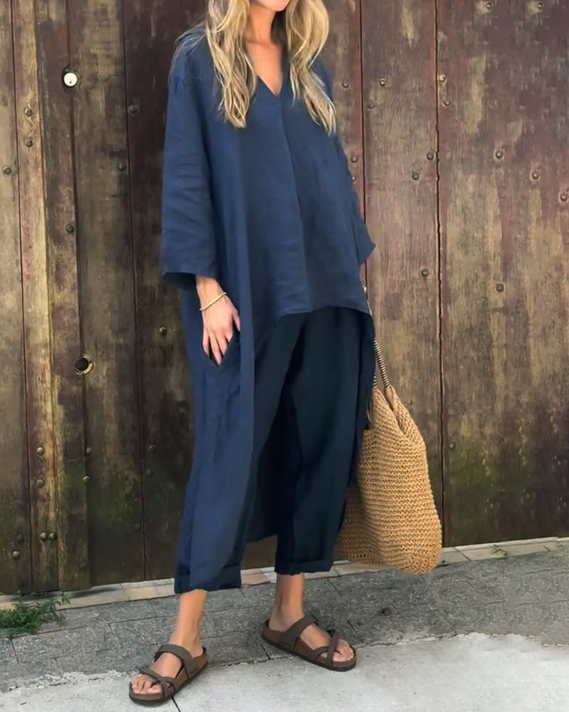 A woman wearing a blue asymmetric tunic with wide-leg pants