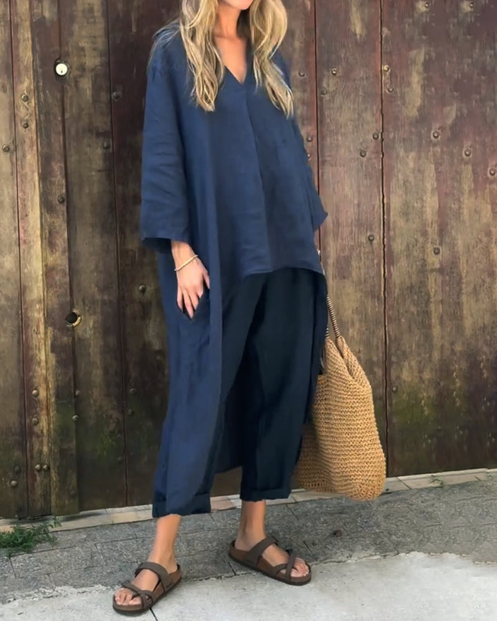 A woman wearing a blue asymmetric tunic with wide-leg pants