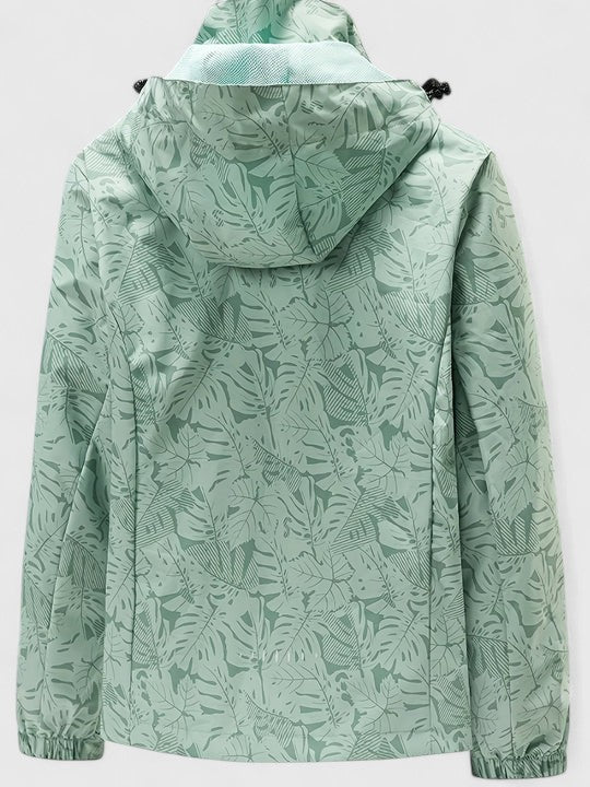 A woman wearing a botanical leaf-print jacket with a hood outdoors