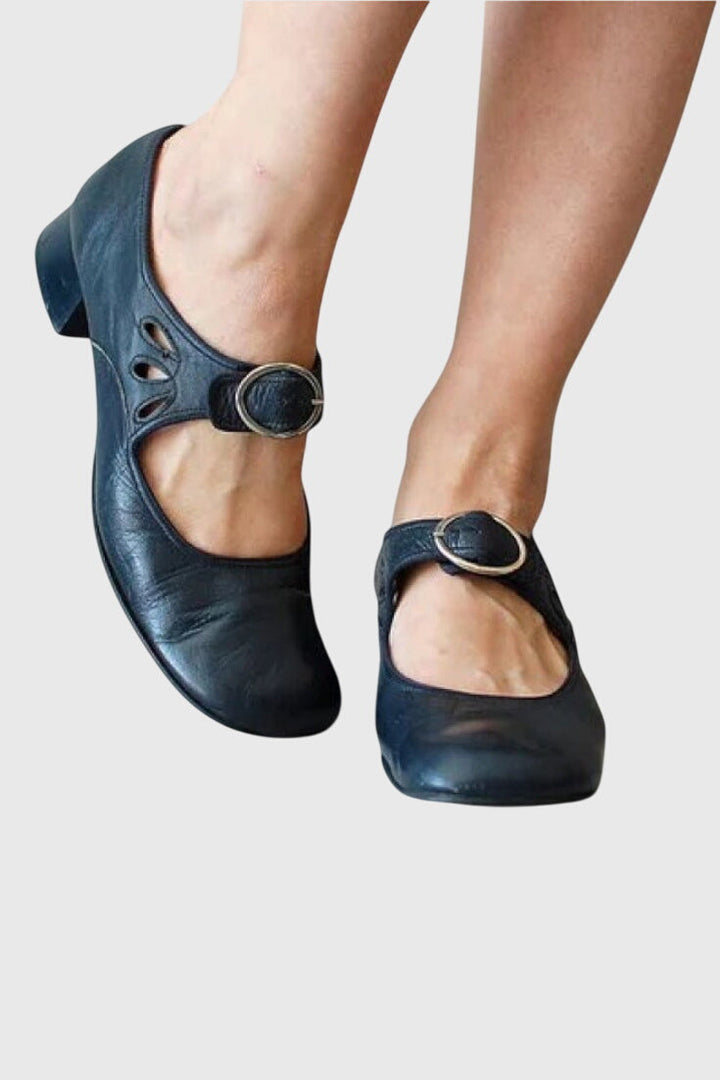 A woman wearing low heel Mary Janes with an adjustable strap, dressed for work.