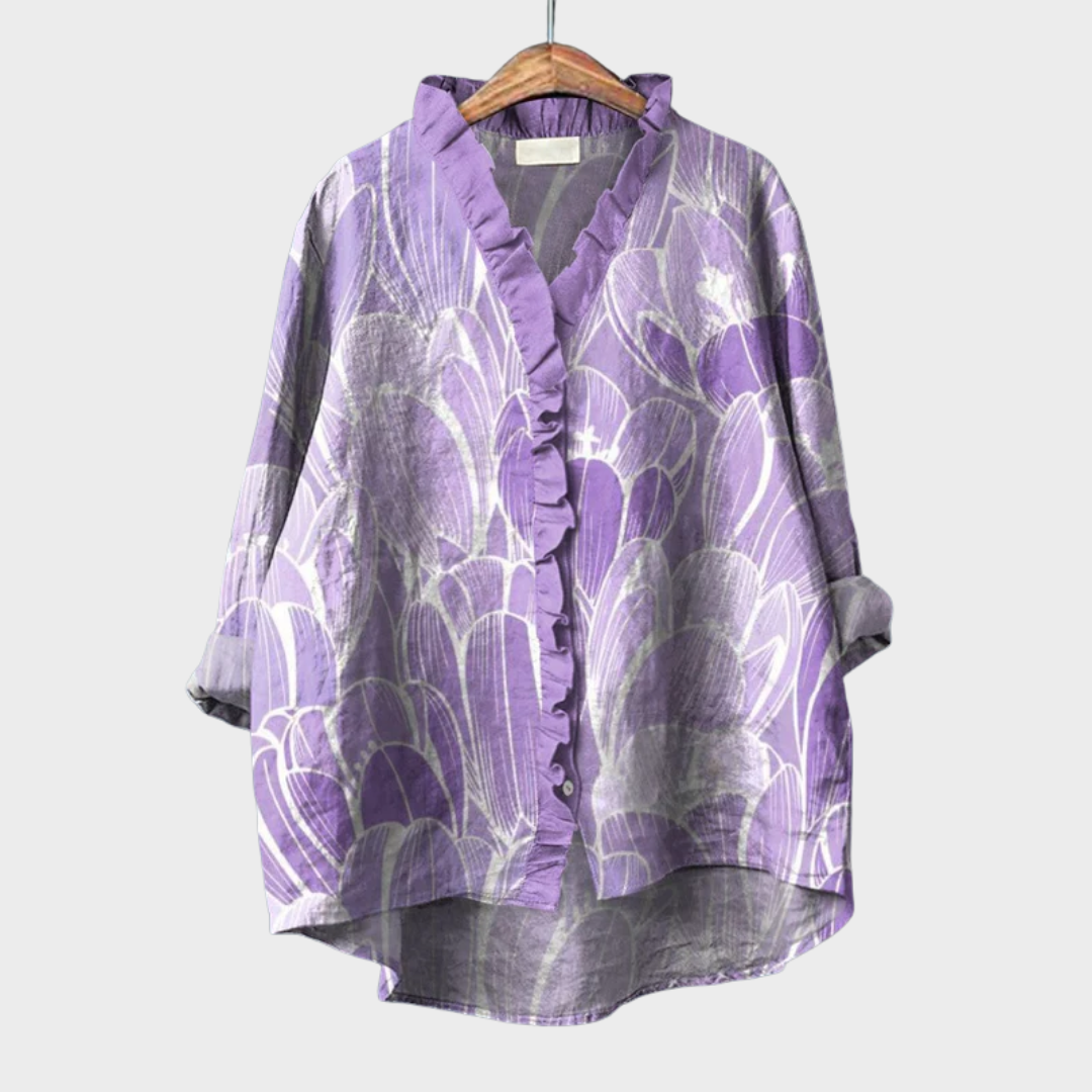 A woman wearing a light violet artful-print summer blouse over simple pants