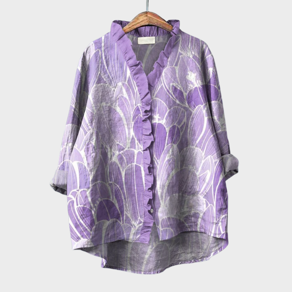 A woman wearing a light violet artful-print summer blouse over simple pants