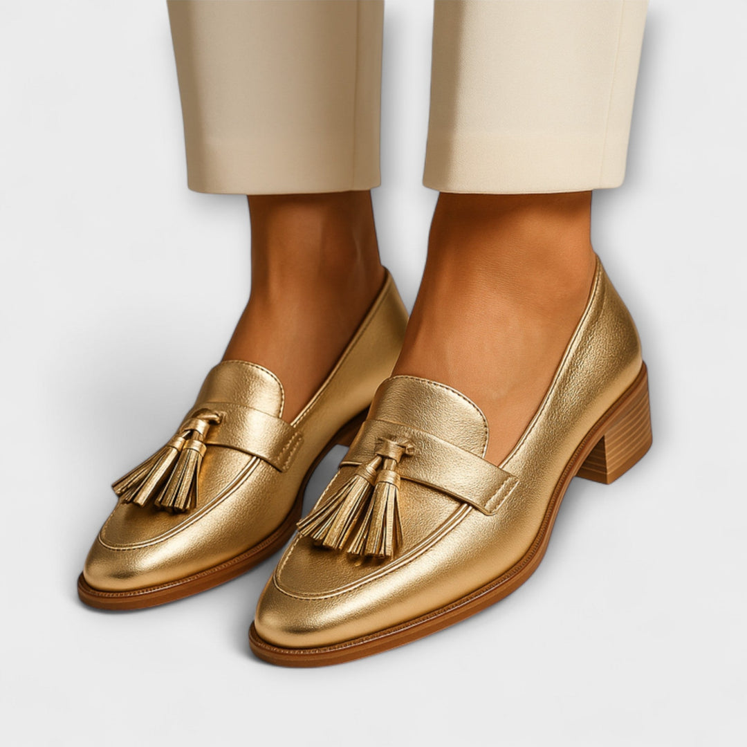 A woman wearing shimmering gold loafers with a festive outfit