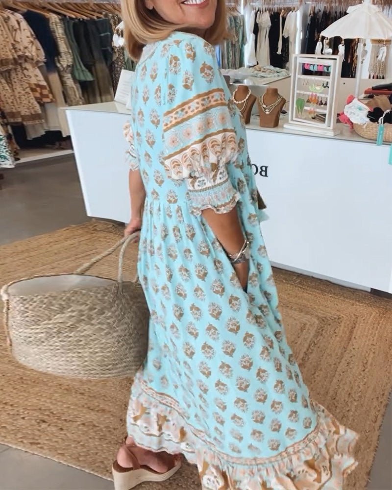 A woman wearing the Tracy boho floral midi dress with a fringed neckline and ruffled skirt.