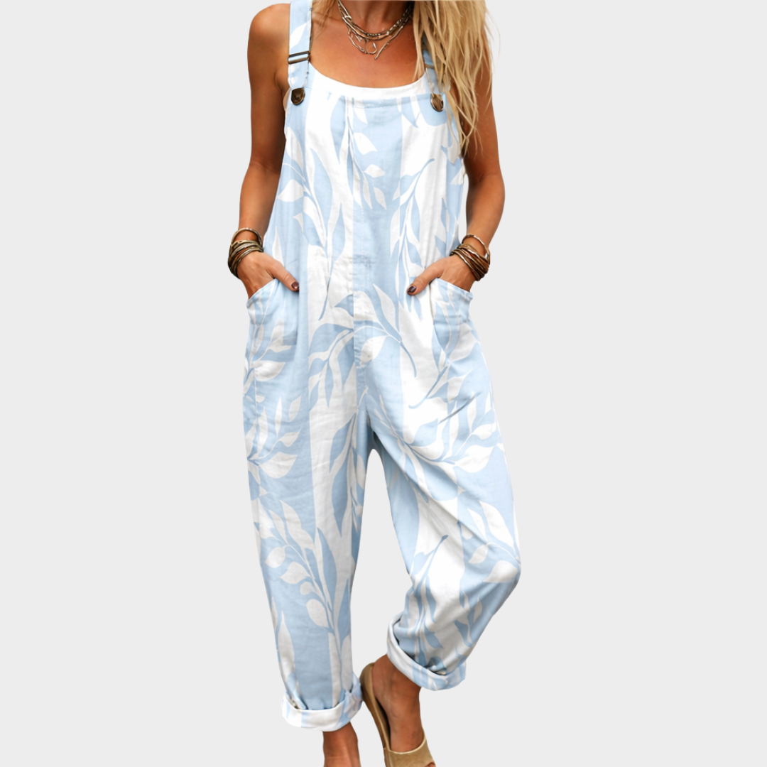 Woman wearing light blue and white leaf-print overalls with adjustable straps, fresh and relaxed.