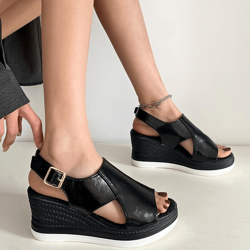 A woman wearing gold metallic sandals with a cushioned insole and wide, supportive fit.