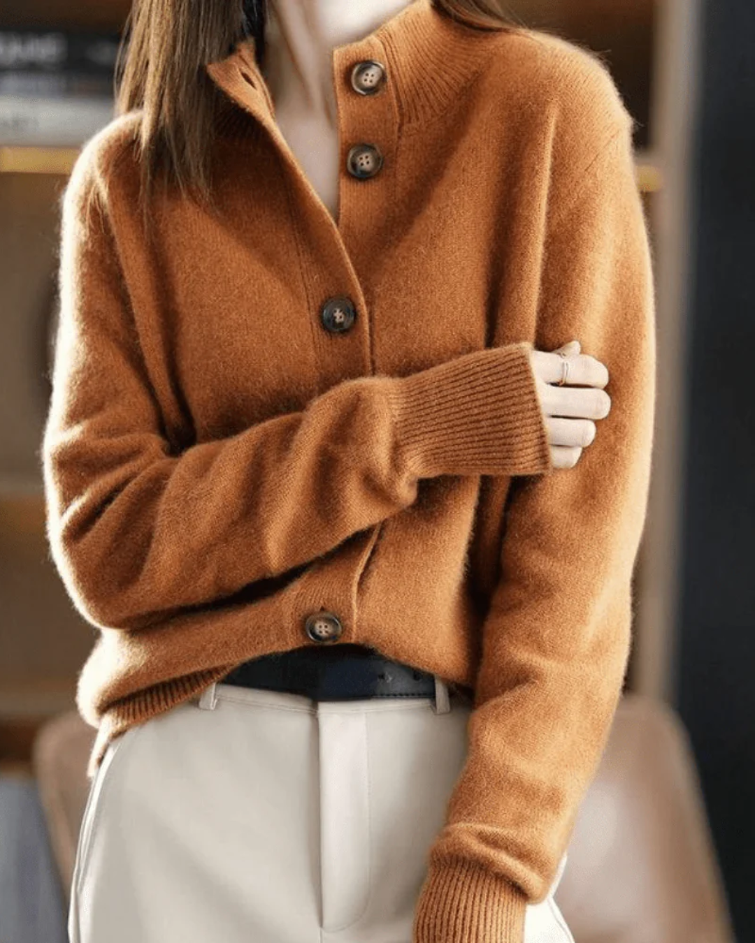 A woman wearing a beige retro button cardigan layered over a dress, warm and elegant.